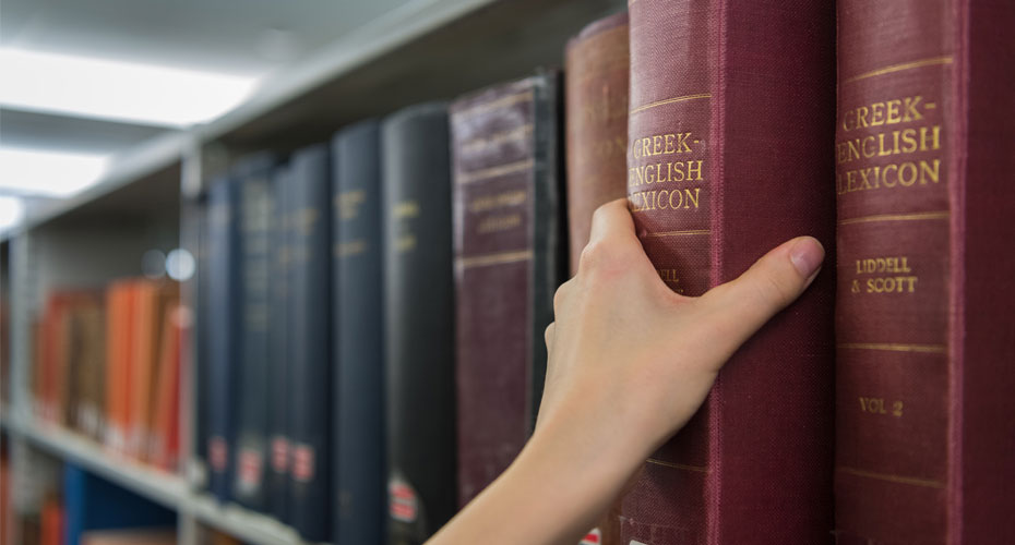 Hand removing book from shelf